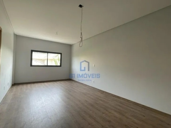 Suíte plena com paredes brancas e piso amadeirado, pronta para personalização de armários.