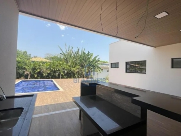 Área gourmet integrada com bancada em granito escuro e vista para a área de lazer externa.