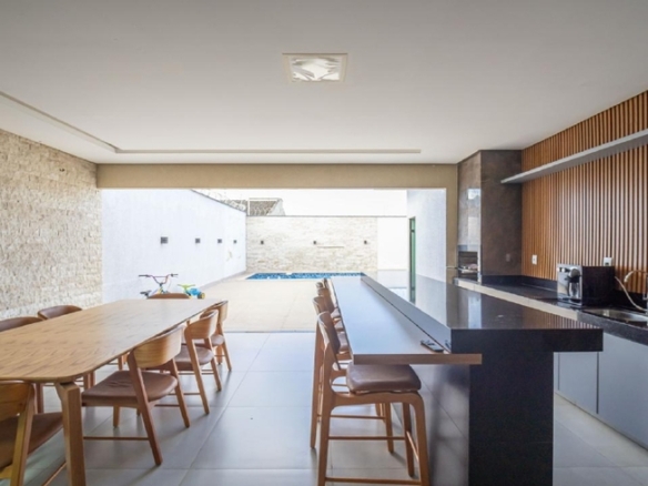Área gourmet com mesa de jantar e painel de madeira