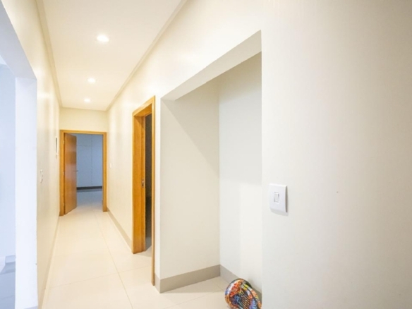 Corredor interno iluminado com acesso aos quartos