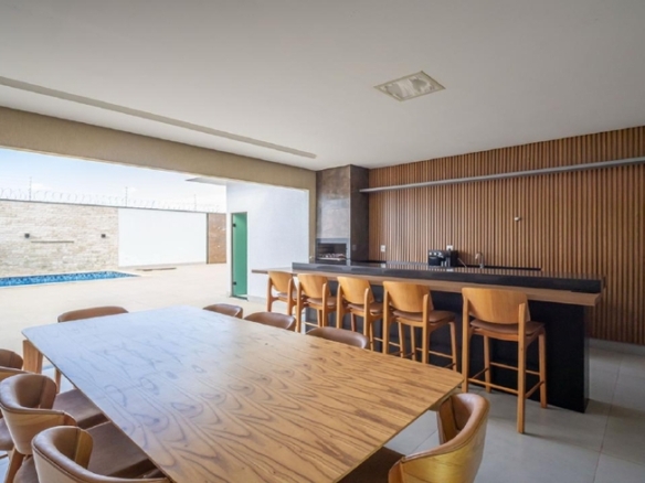 Espaço gourmet com mesa de madeira e armários planejados