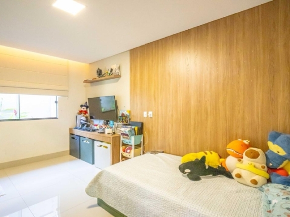 Quarto infantil com cama branca, brinquedos e painel de madeira