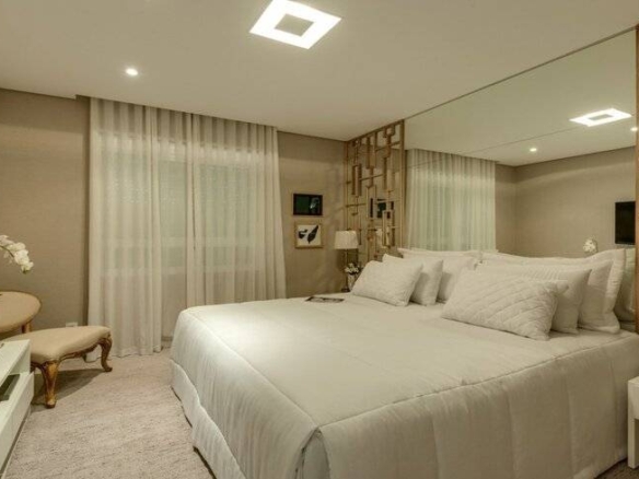 Quarto com cama, espelho e tapete