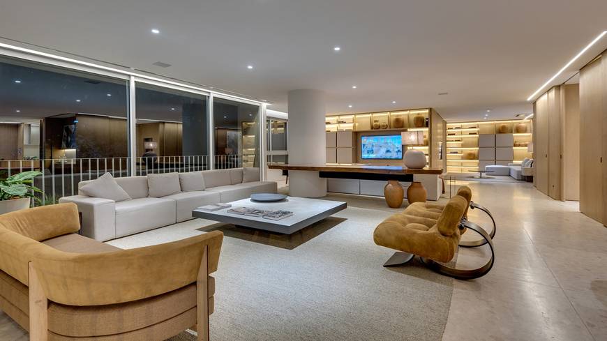 Sala de estar com sofá, mesa e luminária, além de iluminação embutida no Epic City Home