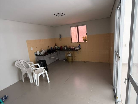 Sala de estar com cadeiras, mesa e janelas, além de iluminação embutida