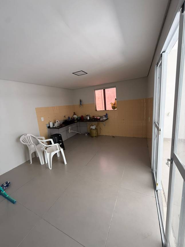 Sala de estar com cadeiras, mesa e janelas, além de iluminação embutida