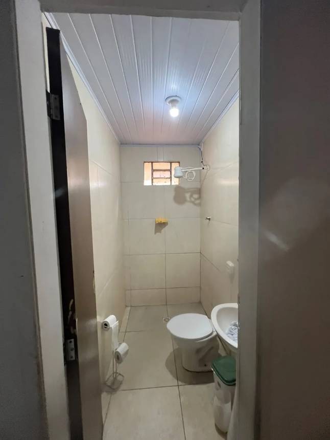 007-casa-com-ponto-comercial-no-parque-amazonia-banheiro-pia-vaso-sanitario Banheiro com pia, vaso sanitário e bancada, além de iluminação embutida e revestimento de madeira no Casa com ponto comercial no Parque Amazônia