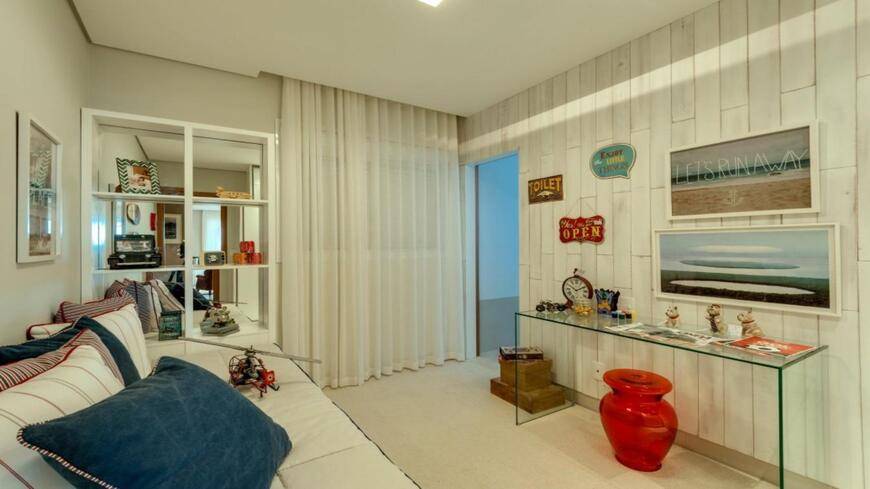 Sala de estar com painel de televisão e cadeiras, além de iluminação embutida