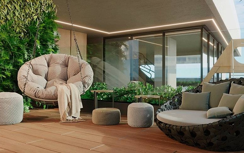 Sala de estar com sofá, mesa e poltronas, além de iluminação embutida
