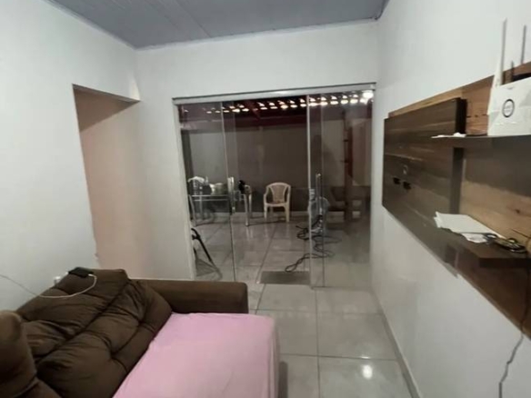 Sala de estar com sofá e mesa, além de iluminação embutida