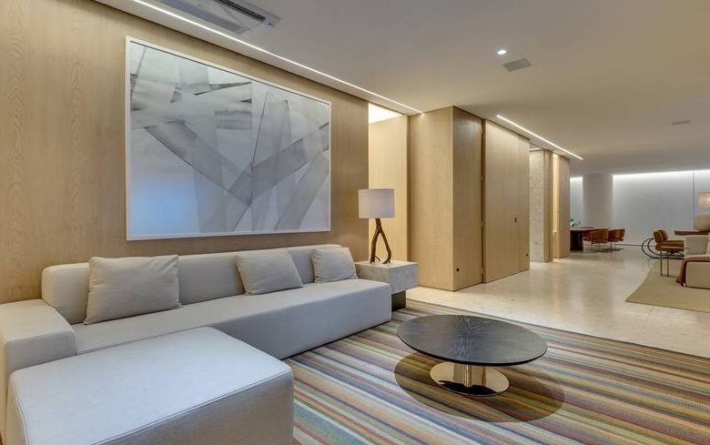 Sala de estar com sofá e mesa, além de iluminação embutida no Epic City Home