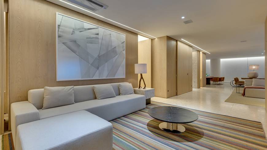 Sala de estar com sofá e mesa, além de iluminação embutida no Epic City Home