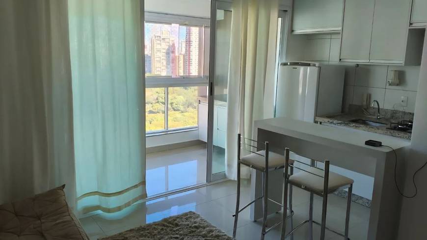 Sala de estar com mesa, cadeiras e janelas