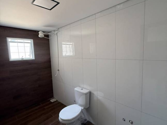 Banheiro com pia e vaso sanitário, além de iluminação embutida
