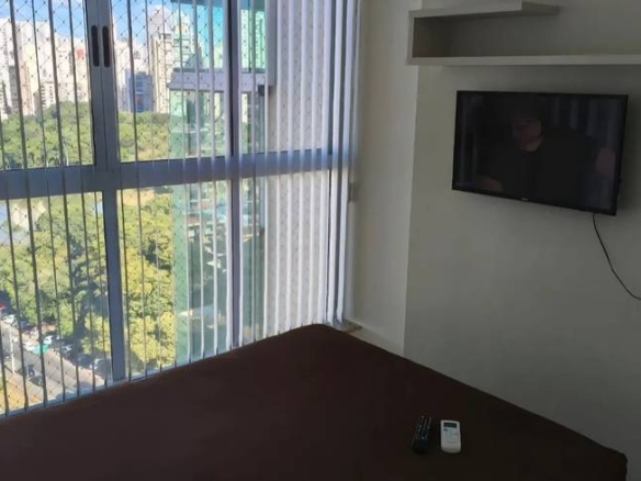 Sala de estar com televisão e janelas
