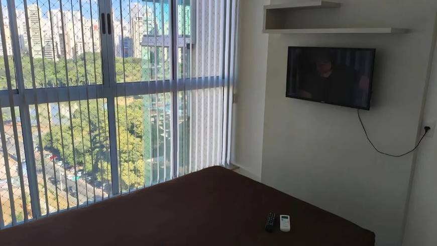 Sala de estar com televisão e janelas
