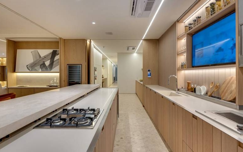 Cozinha com pia, além de iluminação embutida e revestimento de madeira no Epic City Home