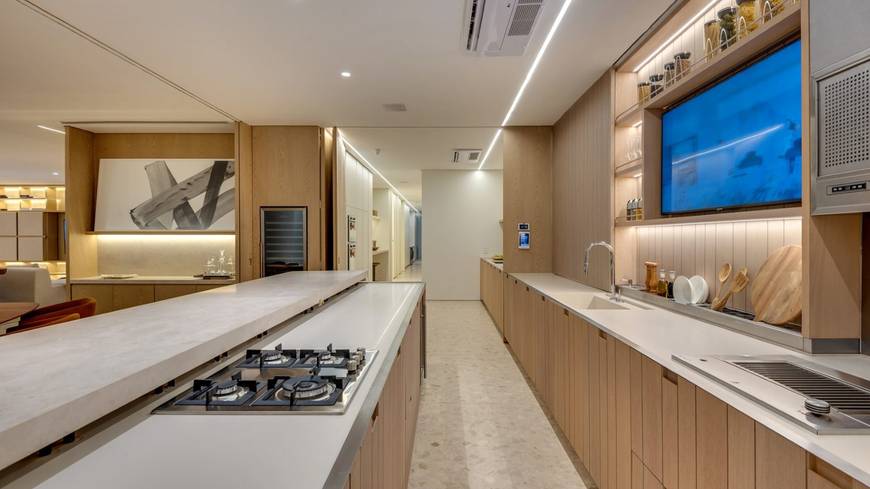 Cozinha com pia, além de iluminação embutida e revestimento de madeira no Epic City Home