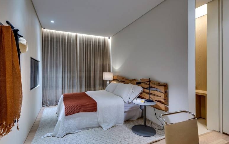Ambiente interno com cama e armário, além de iluminação embutida