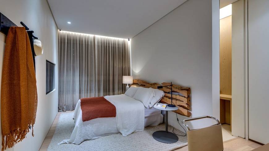 Ambiente interno com cama e armário, além de iluminação embutida