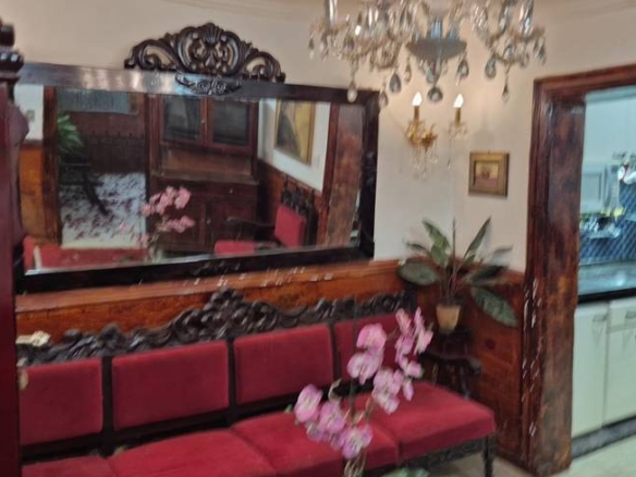 Ambiente interno com espelho, cadeiras e luminária, além de iluminação embutida e revestimento de madeira no Casa mobiliada no Jardim Novo Mundo