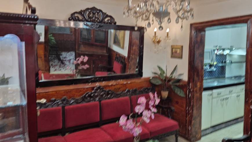 Ambiente interno com espelho, cadeiras e luminária, além de iluminação embutida e revestimento de madeira no Casa mobiliada no Jardim Novo Mundo