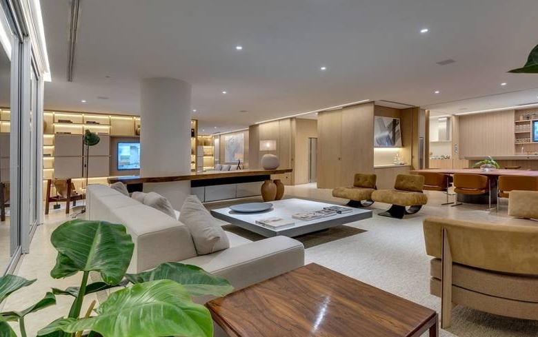 Sala de estar com sofá e televisão, além de iluminação embutida