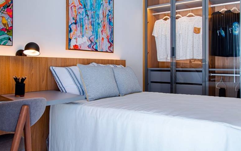 Quarto com cama e armário, além de iluminação embutida