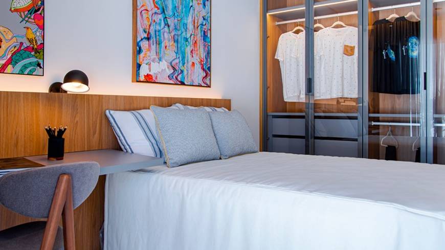 Quarto com cama e armário, além de iluminação embutida