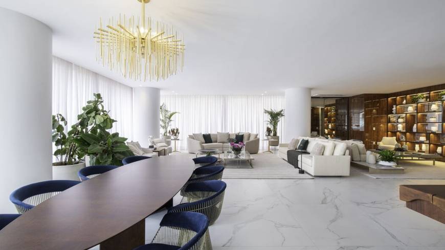 Sala de estar com mesa, cadeiras e luminária