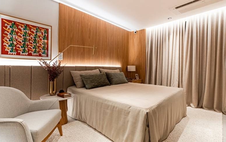 Ambiente interno com cama, armário e luminária, além de iluminação embutida