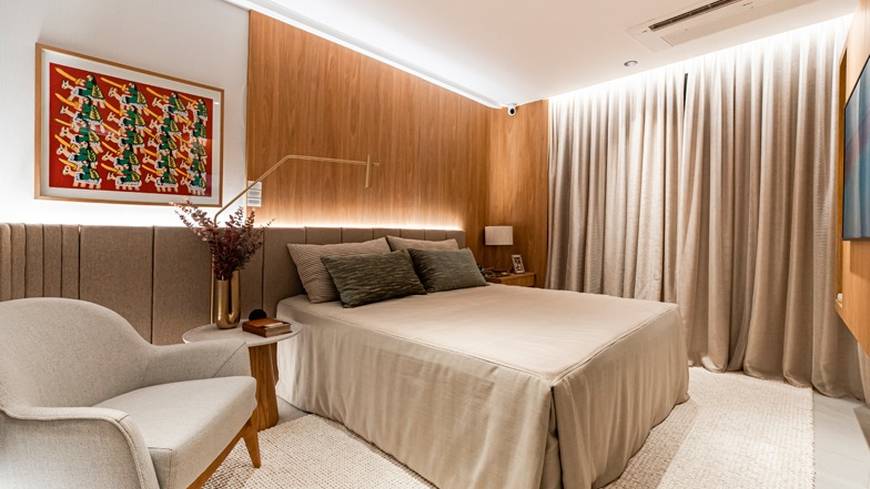 Ambiente interno com cama, armário e luminária, além de iluminação embutida
