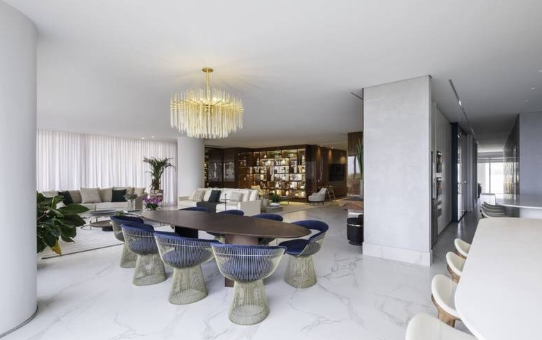 Sala de estar com mesa, cadeiras e luminária, além de iluminação embutida