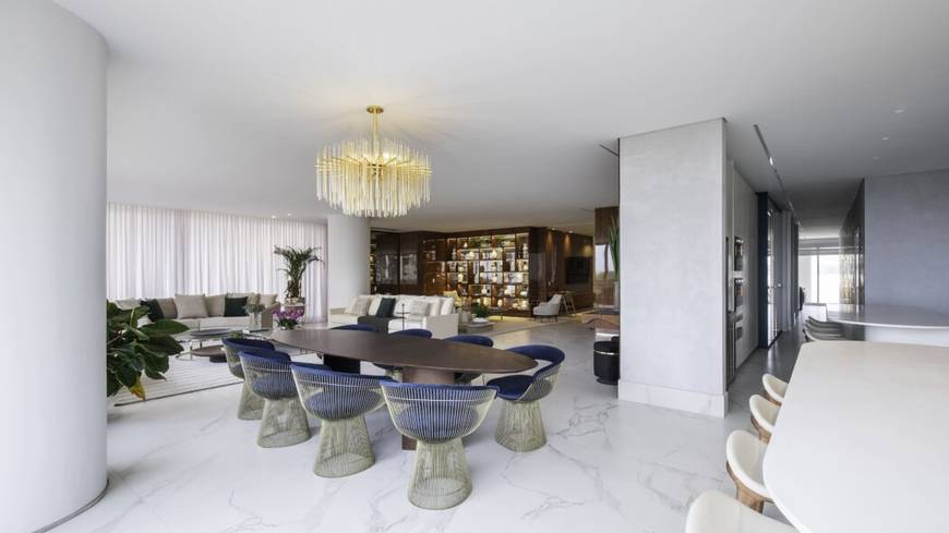 Sala de estar com mesa, cadeiras e luminária, além de iluminação embutida