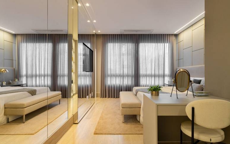 Ambiente interno com cama, espelho e luminária, além de iluminação embutida