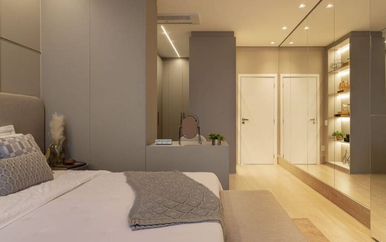 Quarto com cama e armário, além de iluminação embutida e revestimento de madeira
