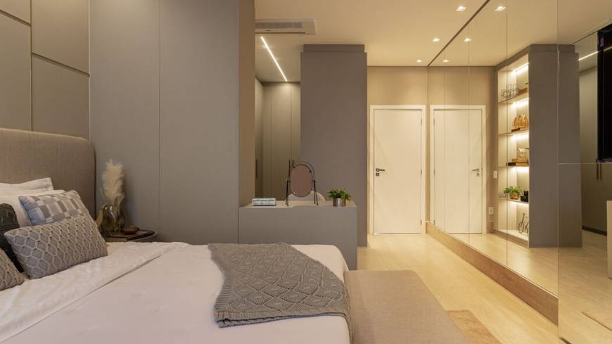 Quarto com cama e armário, além de iluminação embutida e revestimento de madeira