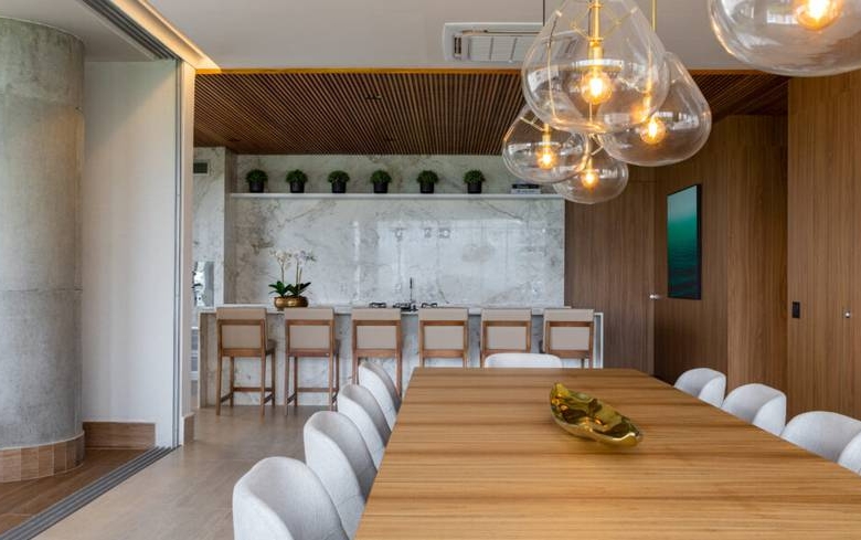 Sala de estar com mesa e luminária, além de iluminação embutida no Epic City Home