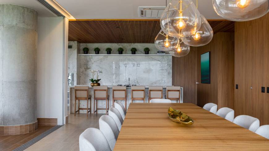 Sala de estar com mesa e luminária, além de iluminação embutida no Epic City Home