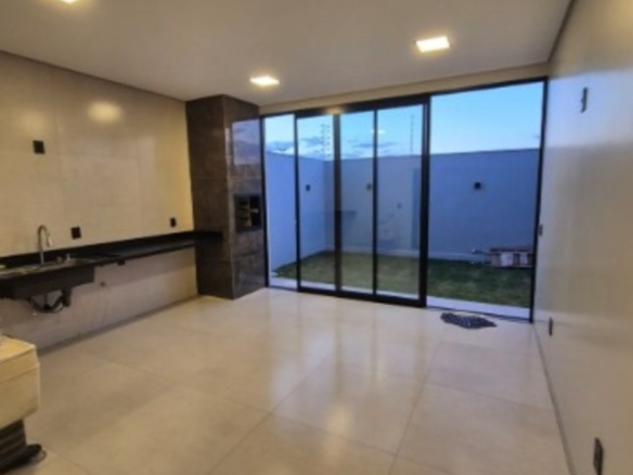 Sala de estar integrada à cozinha e quintal, com portas de vidro, em casa no Alto Umuarama, Uberlândia, Minas Gerais.