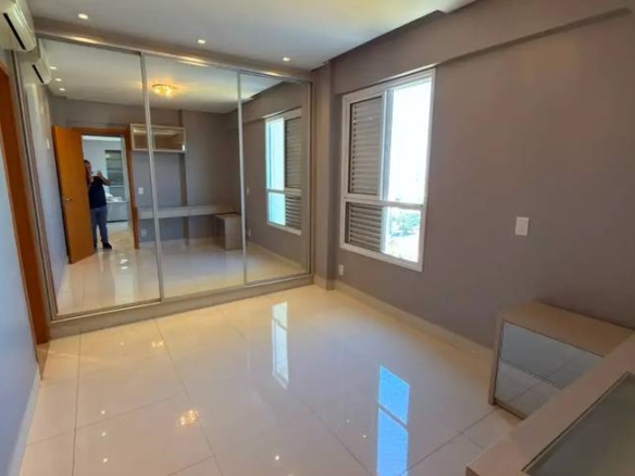 Sala de estar com espelho e janelas, além de iluminação embutida e revestimento claro