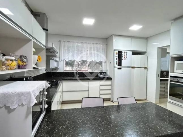 Cozinha com mesa de jantar e cadeiras, além de iluminação embutida e revestimento de madeira