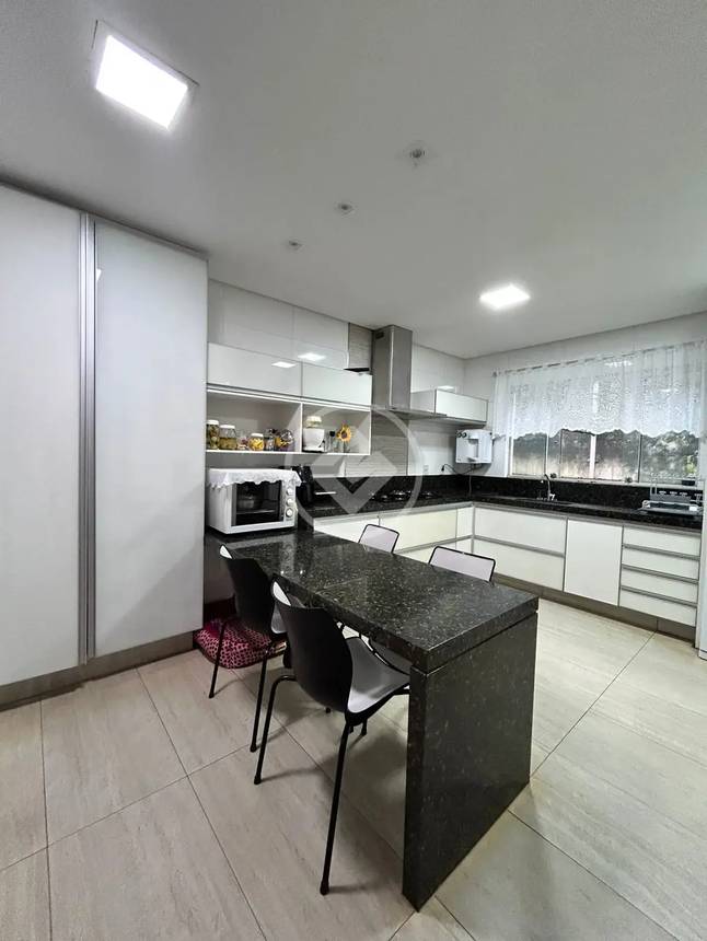 Cozinha com mesa e cadeiras, além de iluminação embutida
