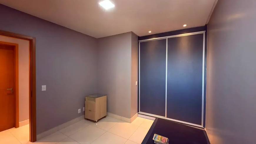 Sala de estar com painel de televisão e luminária