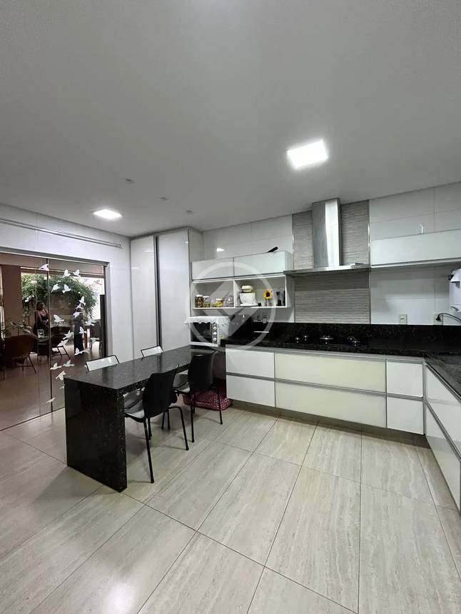 Sala de estar com mesa e cadeiras, além de iluminação embutida