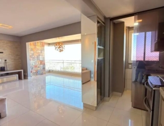 Sala de estar com sofá e tapete, além de iluminação embutida e tons claros