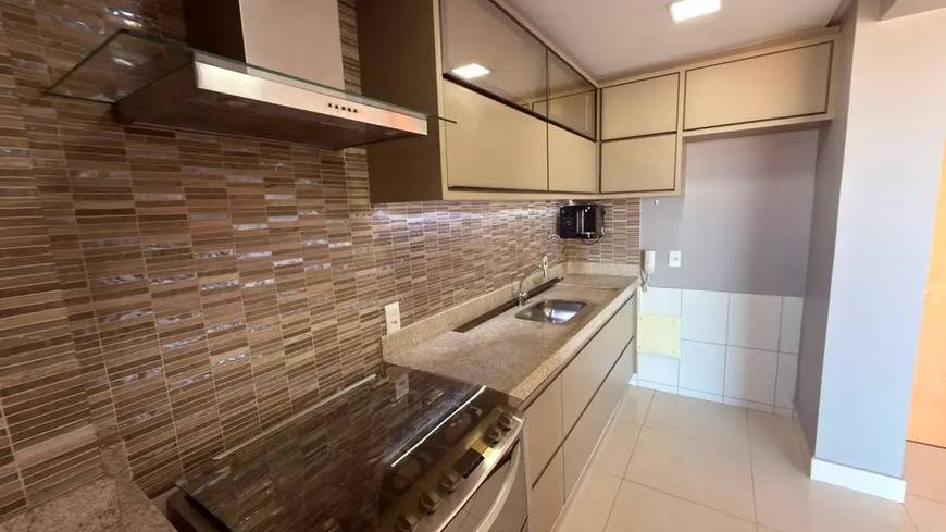 Cozinha, além de iluminação embutida e revestimento de madeira