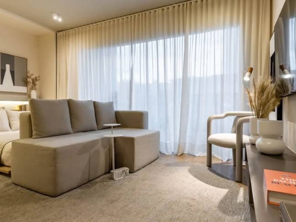 Sala de estar com sofá, mesa e luminária, além de iluminação embutida no Metropolitan Bueno