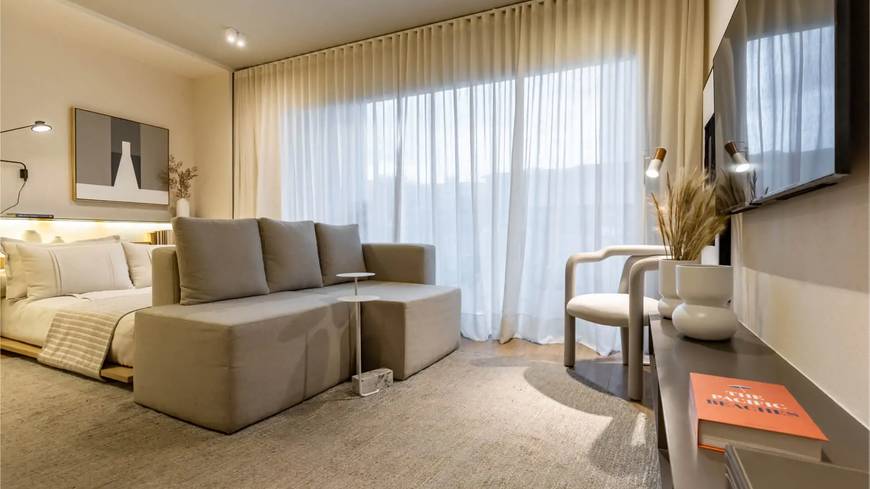 Sala de estar com sofá, mesa e luminária, além de iluminação embutida no Metropolitan Bueno