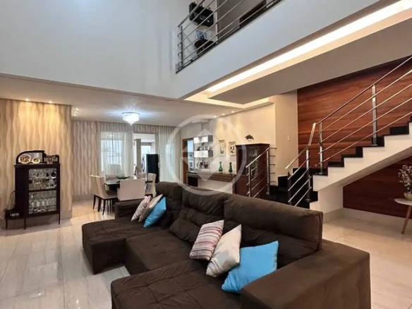 Sala de estar com sofá e mesa, além de iluminação embutida e revestimento claro